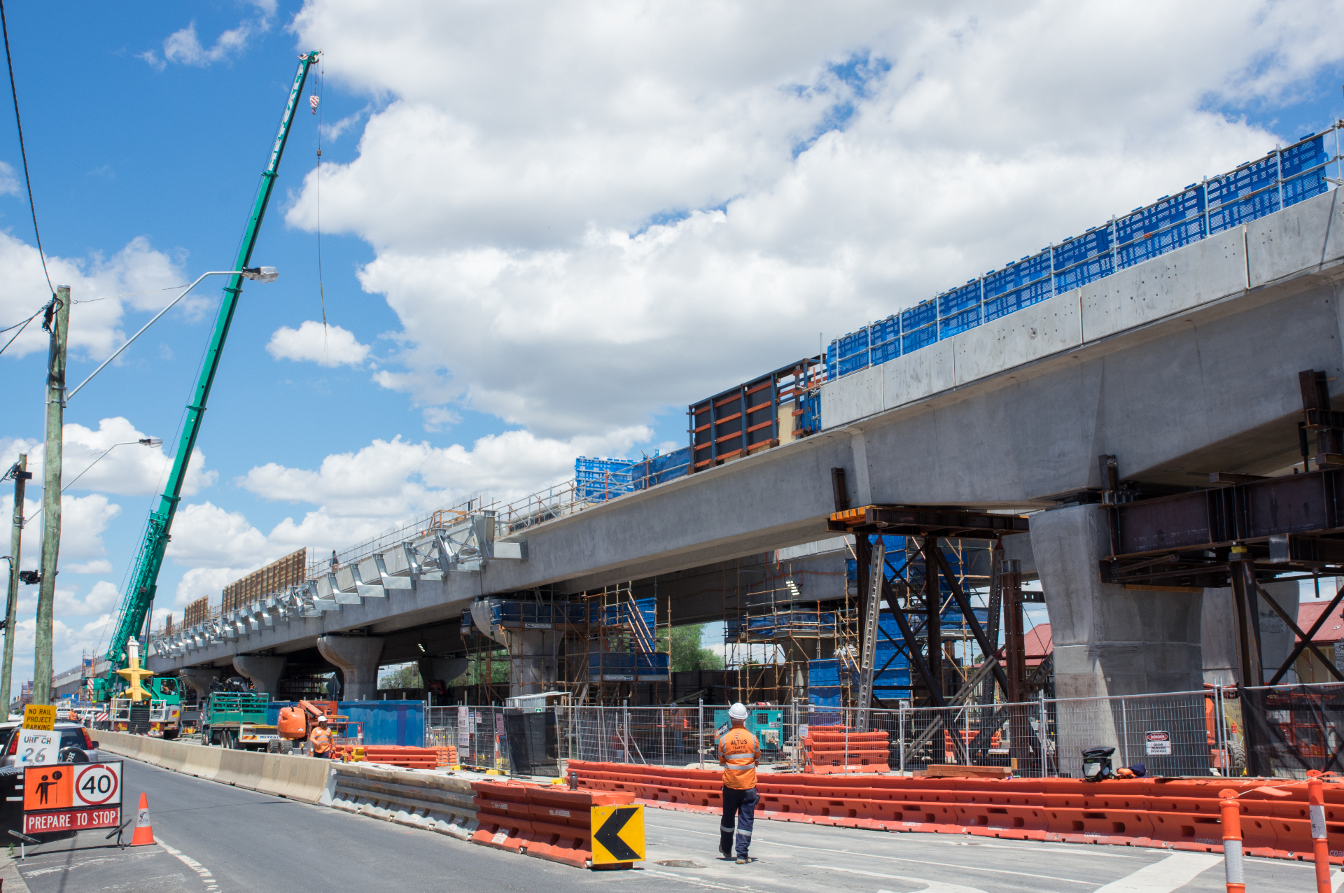 Concrete bridge under construction with tower crane and workers